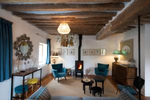 马夫列Les appartements du Domaine de Maffliers 4 étoiles - Demeures de Campagne的客厅配有蓝色椅子和壁炉