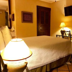 马那瓜Hotel Los Robles, Managua, Nicaragua的卧室配有带灯的白色床