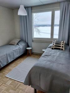 于韦斯屈莱Kotirinne 135 - järven rannalla的一间卧室设有一张床和一个大窗户
