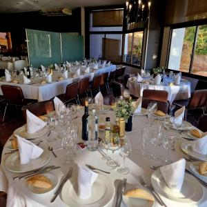 布鲁奇Hotel Bruc的用餐室配有带白色桌布和玻璃杯的桌子