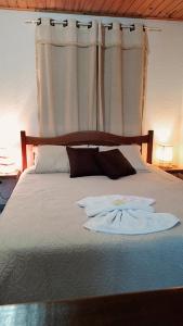 蒙特韦尔迪Chales Encanto Suíço的卧室内的一张带白色床单和枕头的床