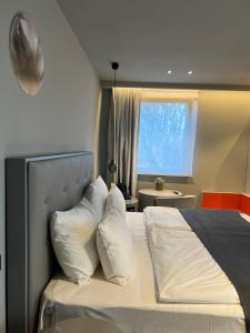 多特蒙德灰色设计酒店 的卧室配有带白色枕头的床和窗户。