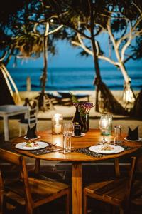 米瑞莎Saltasia Boutique Beach Villa的一张木桌,上面放着食物和玻璃杯