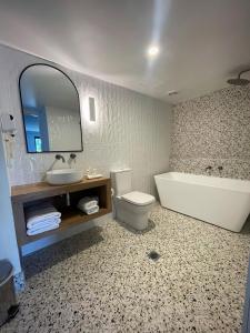 巴特曼斯贝科里甘斯湾酒店的浴室配有卫生间、盥洗盆和浴缸。