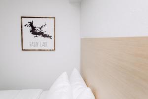 弗朗西斯堡约会酒店的卧室配有白色的床,墙上挂着一幅画