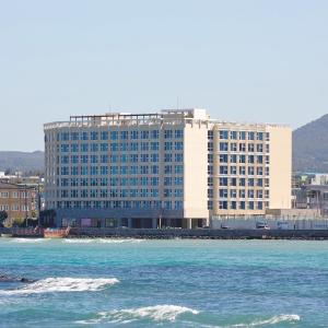 济州市Saint Beach Hotel的水面上一座大型建筑,有一座建筑