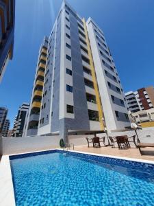 马塞约Apartamentos 250m da Orla -Edifício Nugali- Castelo B Temporada的一座高楼前的游泳池