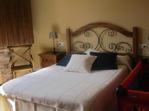 Val de San Lorenzo拉波萨达德托里比亚酒店的卧室配有一张白色大床和木制床头板