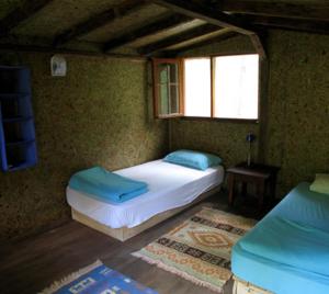 zerguz camping的一间卧室设有两张床和窗户。