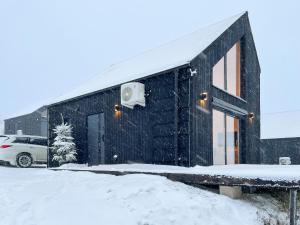 SierpnicaProsportówek - Sierpnica - Domek w Górach z Pięknym Widokiem的屋顶上白雪的黑色建筑