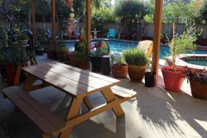 洛杉矶Comfortable Luxury Studio的一张木制野餐桌和一张位于游泳池前的长凳
