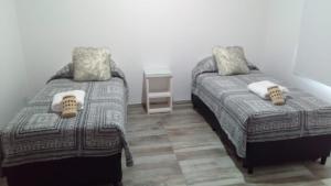 埃尔卡拉法特Apart Azul Calafate的一间卧室设有两张床和床头柜