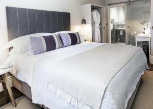 谢菲尔德布罗科公园精品酒店的卧室配有一张带紫色枕头的大型白色床。