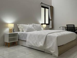 雅加达9 Residence Guesthouse Syariah Cilandak的白色卧室设有一张大床和窗户