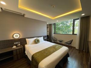 河内3T Hotel Hanoi的一间设有大床和窗户的酒店客房