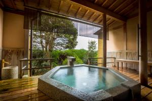 宫津市奇塔诺亚酒店的带大窗户的客房内的热水浴池