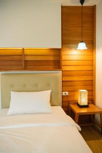 曼谷Cozy House City center BTS&MRT的一间卧室配有一张床和一个带灯的床头柜