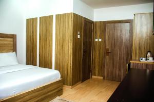 伊凯贾Hotel Capitol的一间卧室配有一张床和一个木制衣柜
