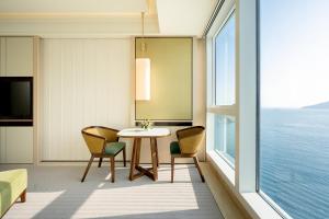 香港香港富丽敦海洋公园酒店的客房设有桌椅和大窗户。