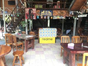 Ban Khlong HaengKoko De Rasta Coffee Lazy house的餐厅设有桌椅和标志,