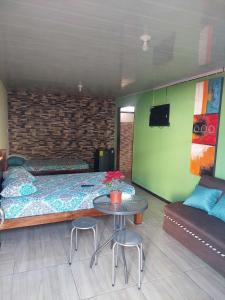 阿拉胡埃拉Anchia的一间卧室配有一张床、一张桌子和一张沙发