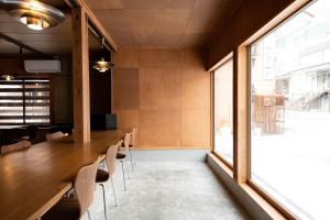 汤泽町Little Japan Echigo的一张大窗房内的长桌子和椅子