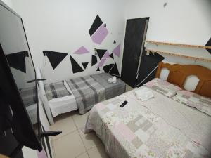 马瑙斯Romulo Ap的一间卧室设有两张床,墙上设有三角形。