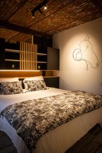 让布卢Le Relais de la Posterie的一间卧室配有一张床,墙上挂着马