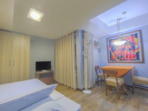 马尼拉Super OYO Capital O 907 Ceo Flats的卧室配有一张床和一张桌子及椅子