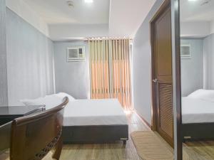 马尼拉Super OYO Capital O 907 Ceo Flats的一间卧室配有两张床、一张桌子和一张桌子