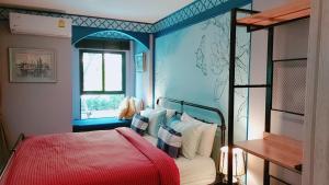 华欣New. Beautiful One Bedroom Pool Access Condo. Only 200 metres to the beach.的一间卧室设有红色的床和蓝色的墙壁