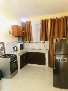 蒙巴萨Mtwapa Apartment的厨房配有棕色橱柜和炉灶烤箱