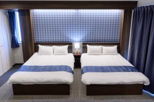 东京Sugamo Winco Residence的酒店客房设有两张床和窗户。