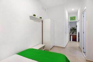 阿鲁卡斯Jardin Cardona的一间白色卧室,床上铺有绿毯