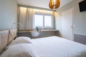 LʼHorme伏尔甘酒店的一间卧室配有床、水槽和窗户