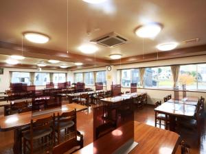 小谷村梅里贝勒栂池酒店的餐厅设有木桌、椅子和窗户。