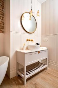 奥尔什丁Apartament Kominek, Jezioro & Las的浴室设有白色水槽和镜子