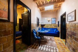 瓦尔扎扎特Hôtel Riad Dar Daïf的一间设有蓝色沙发和一张桌子的房间