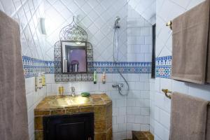 瓦尔扎扎特Hôtel Riad Dar Daïf的一间带水槽和镜子的浴室