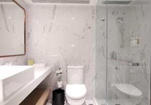香港香港金域假日酒店的浴室配有卫生间、盥洗盆和淋浴。