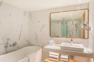 香港香港金域假日酒店的一间带水槽、浴缸和镜子的浴室