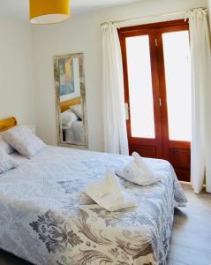 波连萨港Tuent的一间卧室配有带毛巾和镜子的床