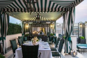 罗马罗马英格兰酒店 - 星际酒店集团的一间带桌椅和条纹天花板的餐厅