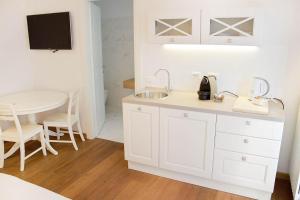 维罗纳坎托雷住宿酒店的白色的厨房配有水槽和桌子