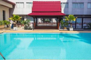 素攀武里松法布里酒店的一座游泳池,毗邻一座建筑,设有凉亭