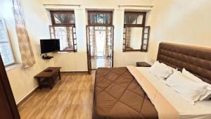 潘奇加尼Citadel Resort的卧室配有床、桌子和窗户。