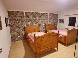 Sennwald24-7 Rooms的砖墙客房的两张床