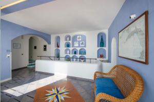 普莱伊亚诺普阿诺马雷斯卡酒店的客厅拥有蓝色的墙壁和藤椅