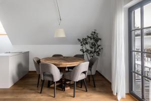萨尔茨堡numa I Nora Apartments的一间带木桌和椅子的用餐室