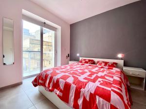 Tal-PietàCentral Private En-Suite with Balcony in shared residence的窗户客房内的一张红白色的床